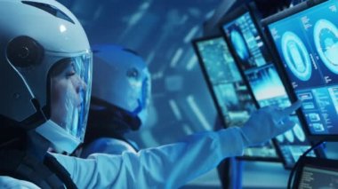 Yörünge istasyonunda uzay giysileri içinde bir astronot ekibi. Uzay gemisine pilotluk eden bir kozmonot mürettebatı. Uzayda kadın ve erkek. Galaktik seyahat ve bilim konsepti.