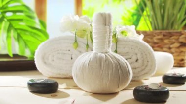 Spa background. Candles, flowers, massaging stones and herbal balls. The concept of massage, oriental therapy, wellbeing and meditation.