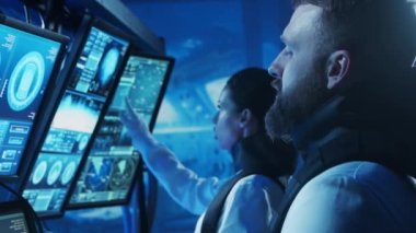 Yörünge istasyonunda uzay giysileri içinde bir astronot ekibi. Uzay gemisine pilotluk eden bir kozmonot mürettebatı. Uzayda kadın ve erkek. Galaktik seyahat ve bilim konsepti.