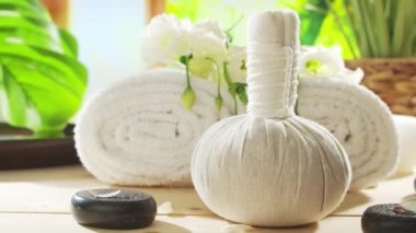 Spa background. Candles, flowers, massaging stones and herbal balls. The concept of massage, oriental therapy, wellbeing and meditation.