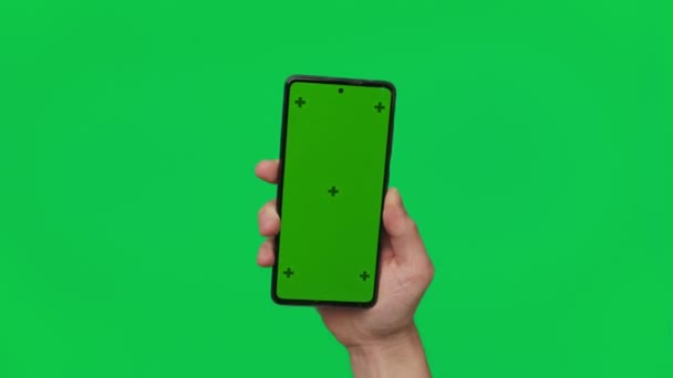 緑の背景に隔離された垂直緑のクロマキー画面を持つスマートフォンを保持男性の手 手に携帯電話 指で異なる兆候やジェスチャー 4Kテンプレート 技術及び — ストック動画