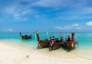 Thai traditional wooden longtail boat and beautiful sand beach in Thailand. The concept of traveling.