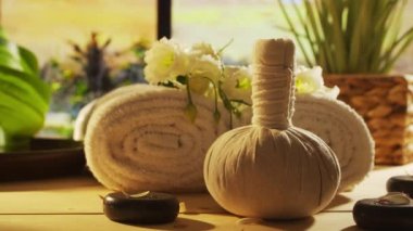 Spa background. Candles, flowers, massaging stones and herbal balls. The concept of massage, oriental therapy, wellbeing and meditation.