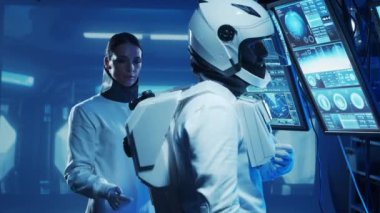 Yörünge istasyonunda uzay giysileri içinde bir astronot ekibi. Uzay giysisini hazırlayan bir kozmonot ekibi. Uzayda kadın ve erkek. Galaktik seyahat ve bilim konsepti.