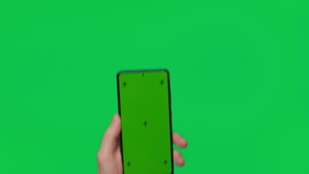 Мужская Рука Держит Смартфон Вертикальным Зеленым Цветным Экраном Изолированным Зеленом — стоковое видео
