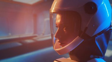 Yörünge istasyonunda uzay giysisi giymiş bir kadın astronot. Genç bir dişi kozmonot bir uzay gemisine pilotluk yapıyor. Galaktik seyahat ve bilim konsepti.