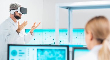 Team of professional scientists working on a vaccine in a modern scientific research laboratory. Genetic engineer workplace. People are using virtual technology for research. Future technology, healthcare and science concept.