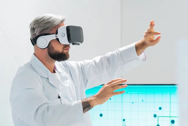 Genetic engineers are using Virtual Reality technology. Professional team of scientists is working on a vaccine in a modern scientific research laboratory. Science of future concept.
