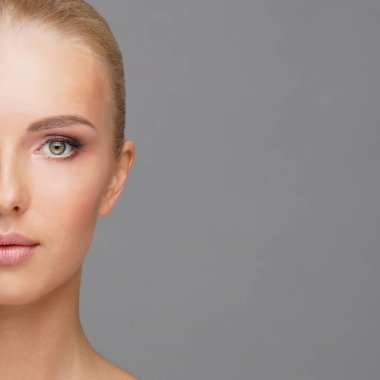 Genç ve sağlıklı kız gri arka plan üzerinde güzel yüzü. Cilt Bakımı, kozmetik ve yüz kavramı kaldırma.