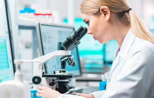 Professional scientist working on a vaccine in a modern scientific research laboratory. Genetic engineer workplace. Laboratory tools: microscope, test tubes, equipment. Future technology, healthcare