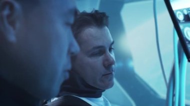 Yörünge istasyonunda uzay giysileri içinde bir astronot ekibi. Uzayda uzay gemisine pilotluk yapan bir kozmonot mürettebatı. Galaktik seyahat ve bilim konsepti.