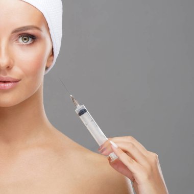 Genç bir kadının yüzüne güzellik aşısı. Estetik ameliyat, cilt gerdirme ve estetik tıp konsepti.