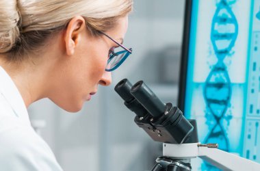 Profesyonel kadın bilim adamı modern bir bilimsel araştırma laboratuvarında aşı üzerinde çalışıyor. Laboratuvar aletleri: mikroskop, test tüpleri, ekipmanlar. Gelecekteki teknoloji, sağlık ve bilim konsepti.