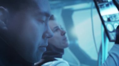 Yörünge istasyonunda uzay giysileri içinde bir astronot ekibi. Uzayda uzay gemisine pilotluk yapan bir kozmonot mürettebatı. Galaktik seyahat ve bilim konsepti.