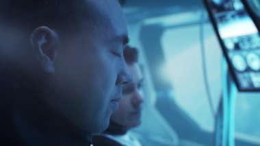 Yörünge istasyonunda uzay giysileri içinde bir astronot ekibi. Uzayda uzay gemisine pilotluk yapan bir kozmonot mürettebatı. Galaktik seyahat ve bilim konsepti.