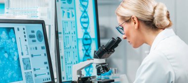 Professional female scientist is working on a vaccine in a modern scientific research laboratory. Laboratory tools: microscope, test tubes, equipment. Future technology, healthcare and science concept