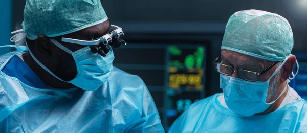 多样化的专业医生团队使用高科技设备和技术 在现代手术室进行外科手术 医生们正在努力抢救医院里的病人 图库照片