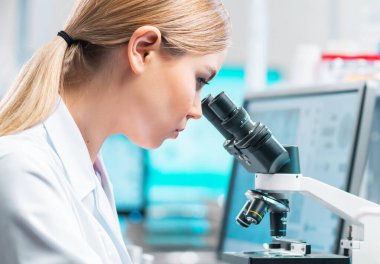 Profesyonel kadın bilim adamı modern bir bilimsel araştırma laboratuvarında aşı üzerinde çalışıyor. Genetik mühendisliği işyeri. Gelecekteki teknoloji ve bilim konsepti.