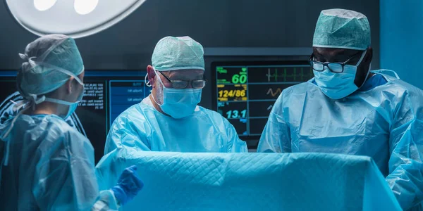 Разнообразная Команда Профессиональных Врачей Проводит Хирургическую Операцию Современной Операционной Использованием — стоковое фото