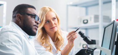 Medical scientists working in lab. Doctor teaching interns to make analyzing research. Laboratory tools: microscope, test tubes, equipment. The concept of biotechnology, bacteriology, virology and
