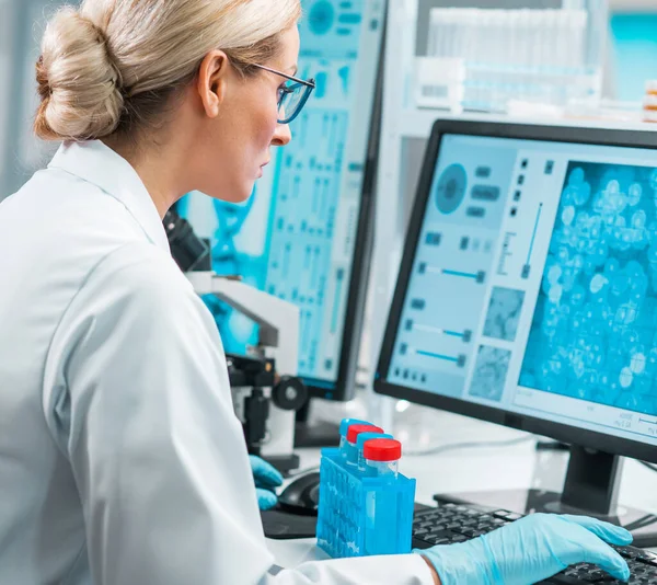 一位专业的女科学家正在一个现代科学研究实验室里研究一种疫苗 实验工具 显微镜 未来的技术 保健和科学概念 — 图库照片