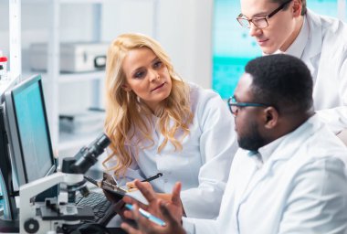 Medical scientists working in lab. Doctor teaching interns to make analyzing research. Laboratory tools: microscope, test tubes, equipment. The concept of biotechnology, bacteriology, virology and