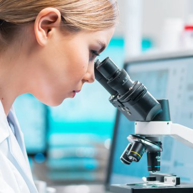 Profesyonel kadın bilim adamı modern bir bilimsel araştırma laboratuvarında aşı üzerinde çalışıyor. Genetik mühendisliği işyeri. Gelecekteki teknoloji ve bilim konsepti.