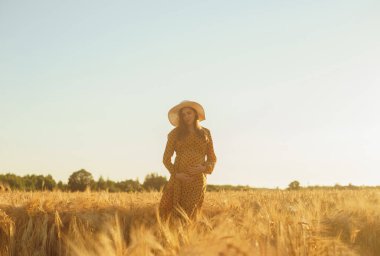 Günbatımında hamile bir kadın. Güzel bir genç kız bir çocuğun doğmasını umarak tarlada yürüyor. Annelik, hamilelik ve mutluluk kavramı..