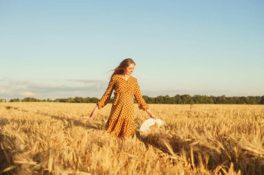 Günbatımında hamile bir kadın. Güzel bir genç kız bir çocuğun doğmasını umarak tarlada yürüyor. Annelik, hamilelik ve mutluluk kavramı..