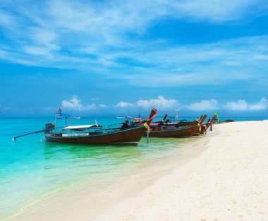 Thai traditional wooden longtail boat and beautiful sand beach in Thailand. The concept of traveling.