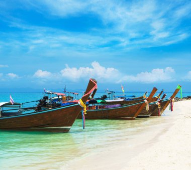 Thai traditional wooden longtail boat and beautiful sand beach in Thailand. The concept of traveling.