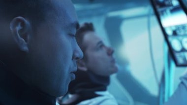 Yörünge istasyonunda uzay giysileri içinde bir astronot ekibi. Uzayda uzay gemisine pilotluk yapan bir kozmonot mürettebatı. Galaktik seyahat ve bilim konsepti.