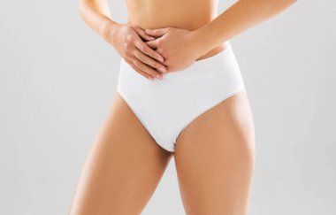 Beyaz arka planda beyaz mayo giyen genç, fit ve güzel bir kadın. Sağlık, diyet, spor ve spor konsepti.