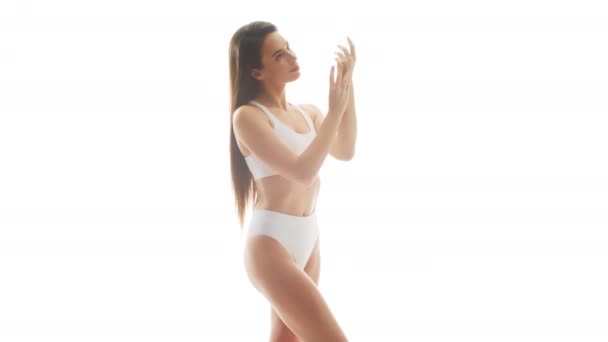 Hermosa Mujer Ropa Interior Blanca Aplicando Crema Sobre Fondo Blanco — Vídeo de stock