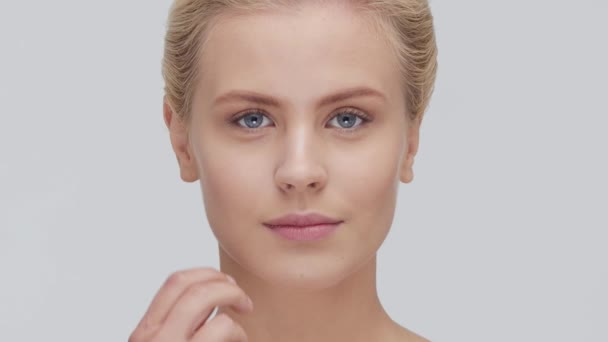 自然的金发女子应用护肤霜的工作室肖像 面部整容 化妆品及化妆的概念 — 图库视频影像