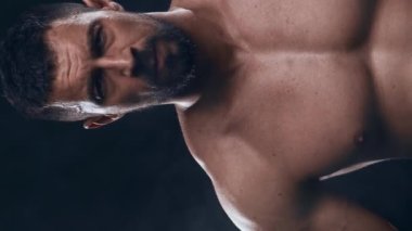 Siyah arka planda formda ve sportif vücut geliştirici. Halter kullanarak vücut geliştirici eğitimi. Spor ve spor kavramları. Dikey video.