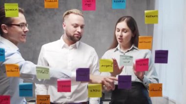 Genç iş adamlarından oluşan bir ekip, camdaki çıkartmaları kullanarak bir toplantıda beyin fırtınası yapıyor. Ofis çalışanları strateji, iş planı ve hedefleri tartışıyorlar. Başlangıç konsepti.