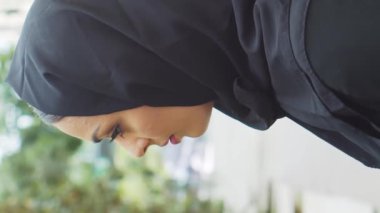 Genç ve kendinden emin, tesettürlü Müslüman bir iş kadınının portresi. Orta Doğulu ofis çalışanı veya iş kadını şehirde açık havada çalışıyor. Dikey video. Şirket ve finansal konsept.