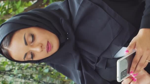 穿着头巾的年轻而自信的穆斯林女商人的画像 中东的办公室职员或女商人在城里室外工作 垂直录像 公司和金融概念 — 图库视频影像