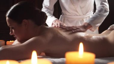 Genç, sağlıklı ve güzel bir kadın spa salonunda masaj terapisi görüyor. Sağlıklı yaşam tarzı ve vücut bakımı kavramı.