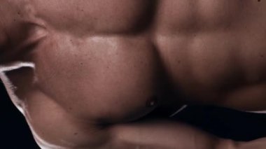 Siyah arka planda formda ve sportif vücut geliştirici. Halter kullanarak vücut geliştirici eğitimi. Spor ve spor kavramları. Dikey video.