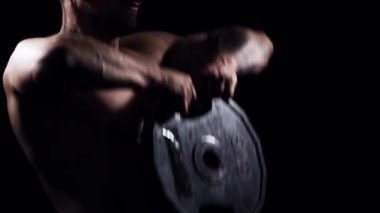 Siyah arka planda formda ve sportif vücut geliştirici. Halter kullanarak vücut geliştirici eğitimi. Spor ve spor kavramları.