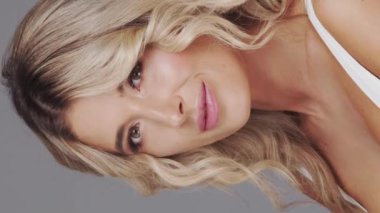 Gri arka planda genç ve güzel sarışın kadının stüdyo portresi. Cilt bakımı ve sağlık kavramı.