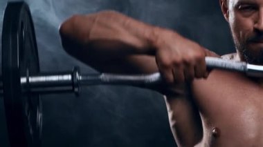 Siyah arka planda formda ve sportif vücut geliştirici. Halter kullanarak vücut geliştirici eğitimi. Spor ve spor kavramları.