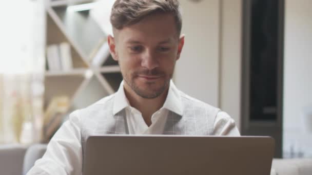 stock video Businessman sitting and working in a cafe. Man using computer and devices. The concept of business and entrepreneurship.