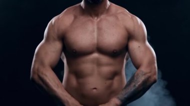 Siyah arka planda formda ve sportif vücut geliştirici. Halter kullanarak vücut geliştirici eğitimi. Spor ve spor kavramları.