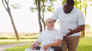 Afro-Amerikalı bakıcı ve yaşlı adam. Bakımevindeki profesyonel hemşire ve hastası. Yardım, rehabilitasyon ve sağlık hizmetleri kavramı.