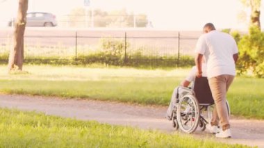 Afro-Amerikalı bakıcı ve yaşlı adam. Bakımevindeki profesyonel hemşire ve hastası. Yardım, rehabilitasyon ve sağlık hizmetleri kavramı.