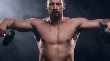 Siyah arka planda formda ve sportif vücut geliştirici. Halter kullanarak vücut geliştirici eğitimi. Spor ve spor kavramları.