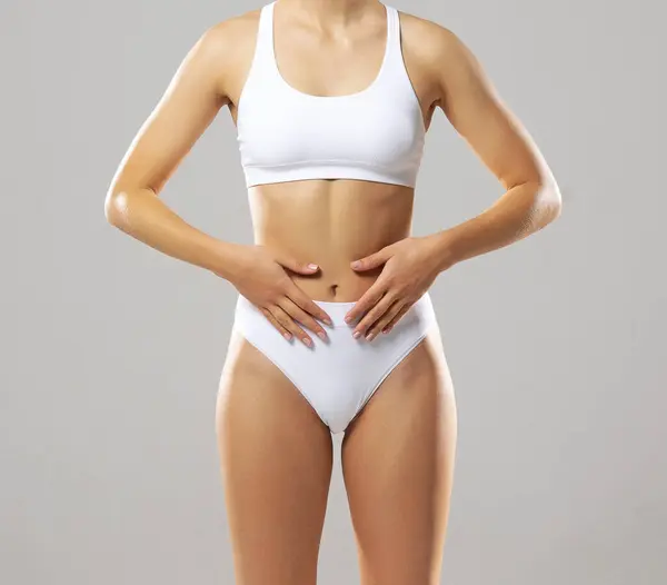 白い背景に白い水着の若く フィットし 美しい女性 ヘルスケア ダイエット スポーツ フィットネスコンセプト ロイヤリティフリーのストック写真
